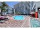 A sparkling outdoor pool featuring lounge chairs, palm trees, and a tiki bar near towering condos for vacation enjoyment at 7200 Ocean Blvd. N # 664, Myrtle Beach, SC 29572