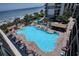 An aerial view of outdoor pool with ocean view near the beach, complete with lounge chairs and tiki bar at 7200 Ocean Blvd. N # 664, Myrtle Beach, SC 29572