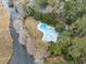 Aerial view of a kidney bean-shaped backyard pool surrounded by lush trees and shrubbery at 741 Tuckers Rd., Pawleys Island, SC 29585