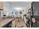 Bright open floor plan kitchen showcases the granite countertops, neutral cabinets and black appliances at 8570 Hopkins Circle # D, Surfside Beach, SC 29575