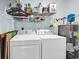 Functional laundry room with modern washer, dryer, water heater, and shelving for extra storage at 8570 Hopkins Circle # D, Surfside Beach, SC 29575