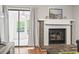 Living room fireplace with brick surround, white mantel, and glass door; sunroom is visible in background at 86 Beaver Pond Loop # 33, Pawleys Island, SC 29585