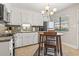 Cozy eat-in kitchen with white cabinets, stainless steel fridge, a hanging light fixture, and view to the outside at 86 Beaver Pond Loop # 33, Pawleys Island, SC 29585