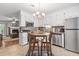 Bright kitchen featuring white cabinetry, stainless steel appliances, a cozy breakfast nook, and access to the living room at 86 Beaver Pond Loop # 33, Pawleys Island, SC 29585
