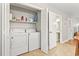 Convenient laundry closet with washer, dryer, shelving for storage, and adjacent access to the bathroom at 86 Beaver Pond Loop # 33, Pawleys Island, SC 29585