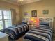 Inviting bedroom with two twin beds, stylish blue striped bedding, and a bright, sunny window at 1000 Ray Costin Way # 114, Murrells Inlet, SC 29576
