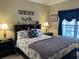 A cozy bedroom featuring a queen-size bed with a nautical-themed headboard and stylish decor at 1000 Ray Costin Way # 114, Murrells Inlet, SC 29576
