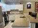 Well-lit kitchen featuring white cabinetry, modern appliances, and a breakfast bar with seating at 1000 Ray Costin Way # 114, Murrells Inlet, SC 29576