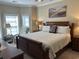 Cozy main bedroom with a large bed, soft lighting, and serene beach-themed artwork at 1000 Ray Costin Way # 114, Murrells Inlet, SC 29576