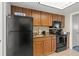 Efficient kitchen featuring wood cabinets, black appliances, sink and tile flooring at 1105 South Ocean Blvd. # 806, Myrtle Beach, SC 29577