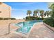 Beautiful outdoor pool with brick trim, a nearby building, and palm trees under a blue sky at 1105 South Ocean Blvd. # 806, Myrtle Beach, SC 29577