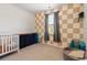 Bright bedroom featuring a crib, dark wood dresser and beige and white square wall design at 112 Rialto Dr., Conway, SC 29526