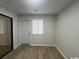 A bedroom with wood-look floors, a white door, and a window with blinds at 116 Hickory Dr., Conway, SC 29526