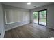 Bedroom featuring neutral walls, wood-look floors, windows, and a sliding glass door to the backyard at 116 Hickory Dr., Conway, SC 29526