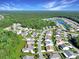 Aerial view of a neighborhood with pond, tree-lined streets, lush greenery, and well-maintained homes at 1250 Camlet Ln., Little River, SC 29566