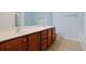 Bathroom featuring double sinks with cherry wood cabinets and a toilet, offering ample counter space at 1250 Camlet Ln., Little River, SC 29566