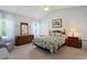 Cozy bedroom featuring soft blue walls, patterned bedding, and an array of wooden furniture at 1250 Camlet Ln., Little River, SC 29566