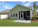 Back exterior of home showcasing a screen door, outdoor patio, grill, and well-manicured lawn at 1250 Camlet Ln., Little River, SC 29566