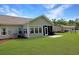 Back exterior of home featuring a screen door, outdoor patio, grill, and expansive lawn at 1250 Camlet Ln., Little River, SC 29566