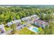 Aerial view of apartments with parking and a pool with lounge chairs surrounded by trees at 1260 White Tree Ln. # F, Myrtle Beach, SC 29588