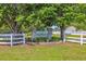 Island Green South community sign framed by lush trees and a white fence at 1260 White Tree Ln. # F, Myrtle Beach, SC 29588