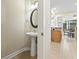 Cozy half-bathroom features a pedestal sink, oval mirror, and view of the breakfast area at 127 Willow Bay Dr., Murrells Inlet, SC 29576