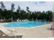 Large swimming pool with lounge chairs surrounded by palm trees at 127 Willow Bay Dr., Murrells Inlet, SC 29576
