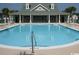 Community swimming pool with chairs and lounge area under the covered building at 127 Willow Bay Dr., Murrells Inlet, SC 29576