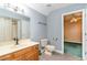 Bathroom featuring a wooden cabinet sink, toilet, and shower with an open doorway at 128 Causey St., Myrtle Beach, SC 29577