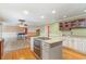 Open kitchen area with a granite-topped island, hardwood floors, and view into the living room at 128 Causey St., Myrtle Beach, SC 29577