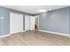The living room has vinyl floors, gray walls, white trim, closet and doorways to another room at 128 Causey St., Myrtle Beach, SC 29577