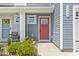 Inviting front door with a vibrant red color and a charming welcome mat and well-maintained landscaping at 136 Villa Grande St. # B, Myrtle Beach, SC 29579