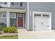 Front door and garage door featuring updated fixtures, a small garden, and stone at 136 Villa Grande St. # B, Myrtle Beach, SC 29579