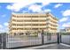 View of the condo's exterior with parking garage, signage and black metal security fence at 1581 S Waccamaw Dr. # 302, Garden City Beach, SC 29576