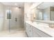 Bright bathroom featuring a glass shower with overhead shower head and a vanity with white cabinets and a large mirror at 1827 Parish Way, Myrtle Beach, SC 29577