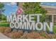 The Market Common sign with floral accents and lush landscaping, indicating the neighborhood's retail at 1827 Parish Way, Myrtle Beach, SC 29577