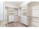 Spacious walk-in closet with custom white shelving and drawers for optimal organization, plus neutral carpeting at 1827 Parish Way, Myrtle Beach, SC 29577