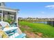 Landscaped backyard with lake view, patio seating, and well-maintained lawn at 189 Timber Oaks Dr., Myrtle Beach, SC 29588