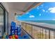Balcony with blue Adirondack chairs and a table provides an ocean view, with beach access below at 200 72Nd Ave. N # 501, Myrtle Beach, SC 29572