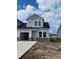 Charming two-story home with a light gray exterior, brick accents, and a spacious two-car garage at 2030 Wild Indigo Circle Nw # 207, Calabash, NC 28467