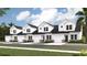 Charming new construction townhomes featuring white siding, brick accents, and attached garages, located in a desirable community at 2004 Wild Indigo Circle Nw # 111, Calabash, NC 28467