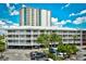 Beautiful exterior shot of condo complex with parking, balconies, and a taller tower in the background against a blue sky at 210 N Ocean Blvd. # 234, North Myrtle Beach, SC 29582