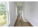 Hallway with wood-look flooring, shiplap accent wall, and a built-in bench, providing a bright and open transition at 2212 Dykman Circle, Little River, SC 29566