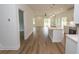 Open-concept kitchen featuring hardwood floors, an island sink, and stainless steel appliances leading to a living area at 2212 Dykman Circle, Little River, SC 29566