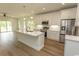 Modern kitchen featuring a large island, stainless steel appliances, and white cabinetry against hardwood floors at 2212 Dykman Circle, Little River, SC 29566