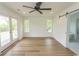 Hardwood floors, neutral walls, ceiling fan, sliding doors leading to a balcony and access to the bathroom are in the main bedroom at 2212 Dykman Circle, Little River, SC 29566