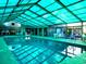 Indoor pool with lounge chairs, large windows, and translucent ceiling at 223 Maison Dr. # D-16, Myrtle Beach, SC 29572