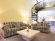 Inviting living room with sofas, a coffee table, and a distinctive spiral staircase at 223 Maison Dr. # D-16, Myrtle Beach, SC 29572