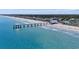 Aerial view shows the pier stretching into the beautiful beach and clear ocean waters at 2262 Andover Dr. # E, Surfside Beach, SC 29575