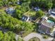 Aerial view of a home surrounded by lush trees in a residential neighborhood with a pool at 228 Hopeland St., Pawleys Island, SC 29585